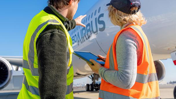 Man pointing at aircraft to lady