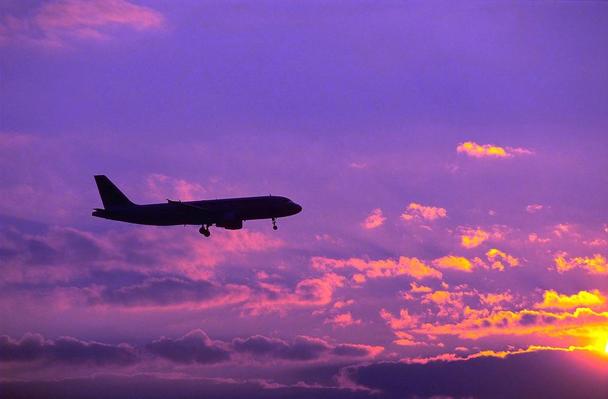 A319 flying at sunset
