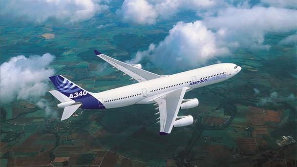 A340 in flight over fields, with Airbus livery