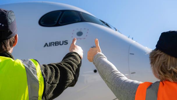 Airbus maintenance people on ground with thumbs up