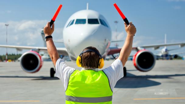 Ramp agent - worker on tarmac guiding aircraft Ramp agent - worker on tarmac guiding aircraft