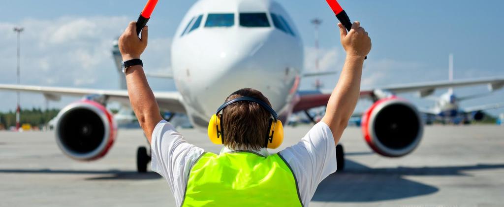 An airport staff member guiding an aircraft