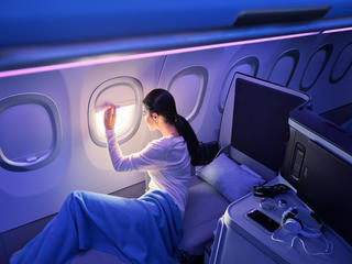 Woman looking through the window in the A320 Airspace cabin.