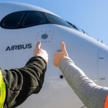 Airbus maintenance people on ground with thumbs up