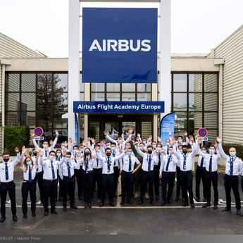 Airbus Flight Academy - cadets in front of building hands in the air