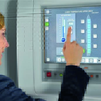 A flight attendant in uniform operating the Flight Attendant Panel (FAP) on the aircraft.