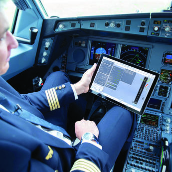 A pilot using a tablet with Flysmart+ displayed while he is in the cockpit
