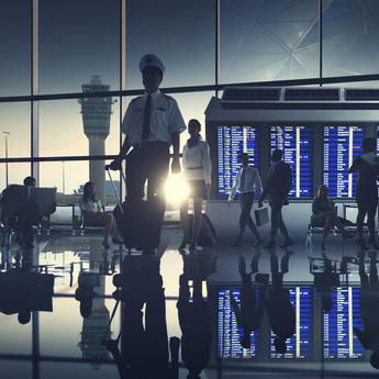A pilot and a crew cabin member walking in the airport