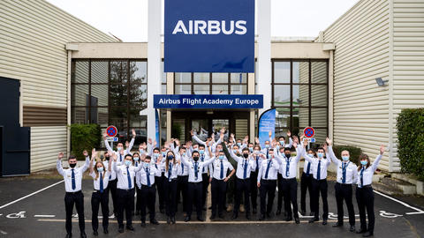 Airbus Flight Academy - cadets in front of building hands in the air