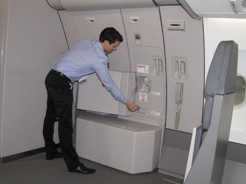 A cabin crew member in uniform closing the door of the aircraft.