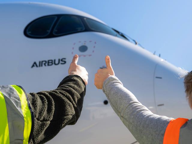 Airbus maintenance people on ground with thumbs up Airbus maintenance people on ground with thumbs up