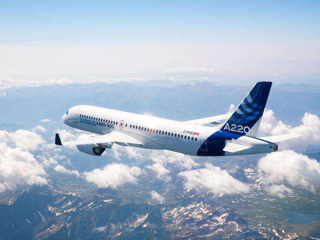 A220-300 aircraft soaring above the clouds.