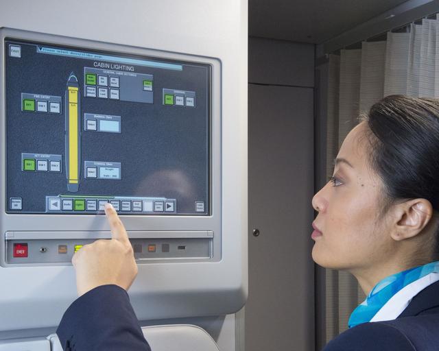 Cabin_crew_basic_training_Digital A flight attendant in uniform operating the Flight Attendant Panel (FAP) on the aircraft.