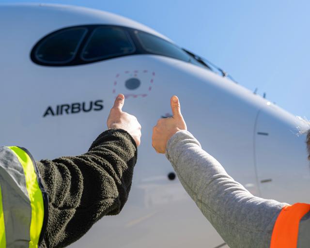 Airbus maintenance people on ground with thumbs up