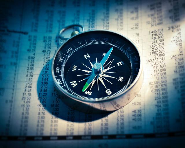 Compass placed on an accounting notebook Compass placed on an accounting notebook