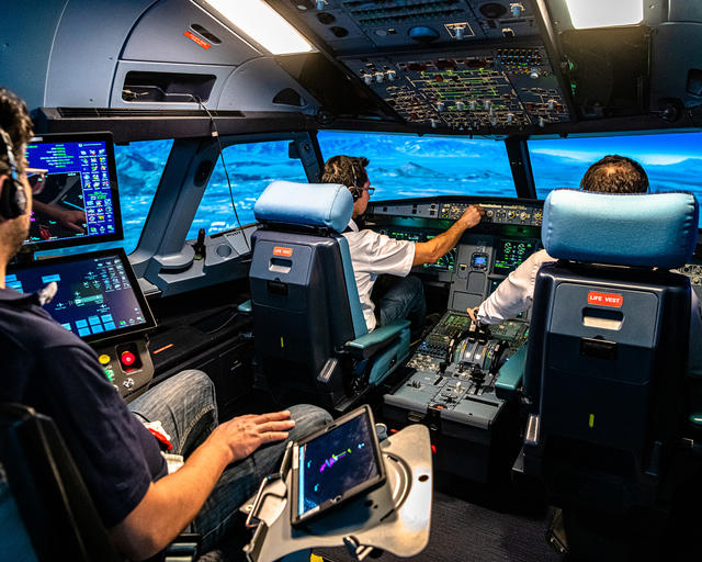 Pilots engaging in a flight training session in a full flight simulator Pilots engaging in a flight training session in a full flight simulator
