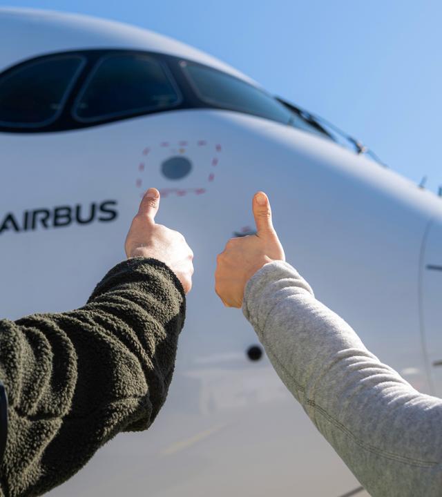 Airbus maintenance people on ground with thumbs up