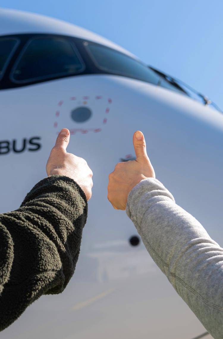 Airbus maintenance people on ground with thumbs up Airbus maintenance people on ground with thumbs up