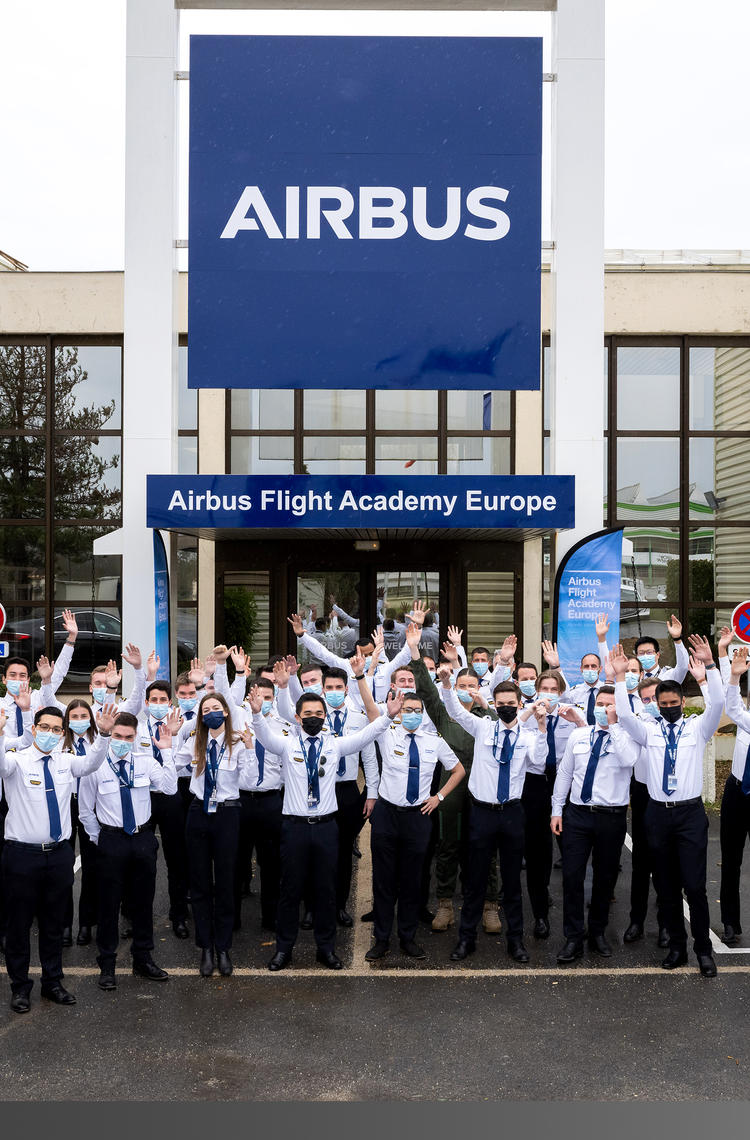 Airbus Flight Academy - cadets in front of building hands in the air