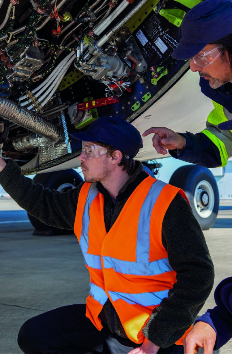 Maintenance training in action with mechanics in safety vests and goggles detecting and inspecting aircraft components