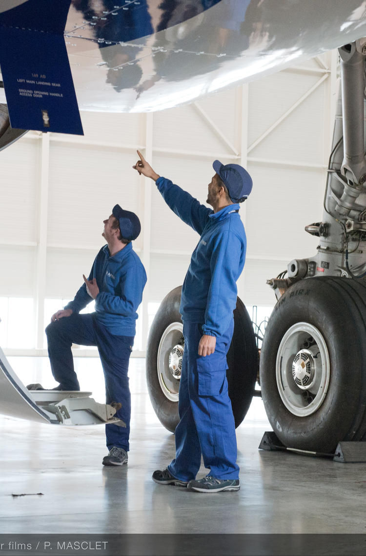 Maintenance technicians checking an aircraft to ensure operational safety.